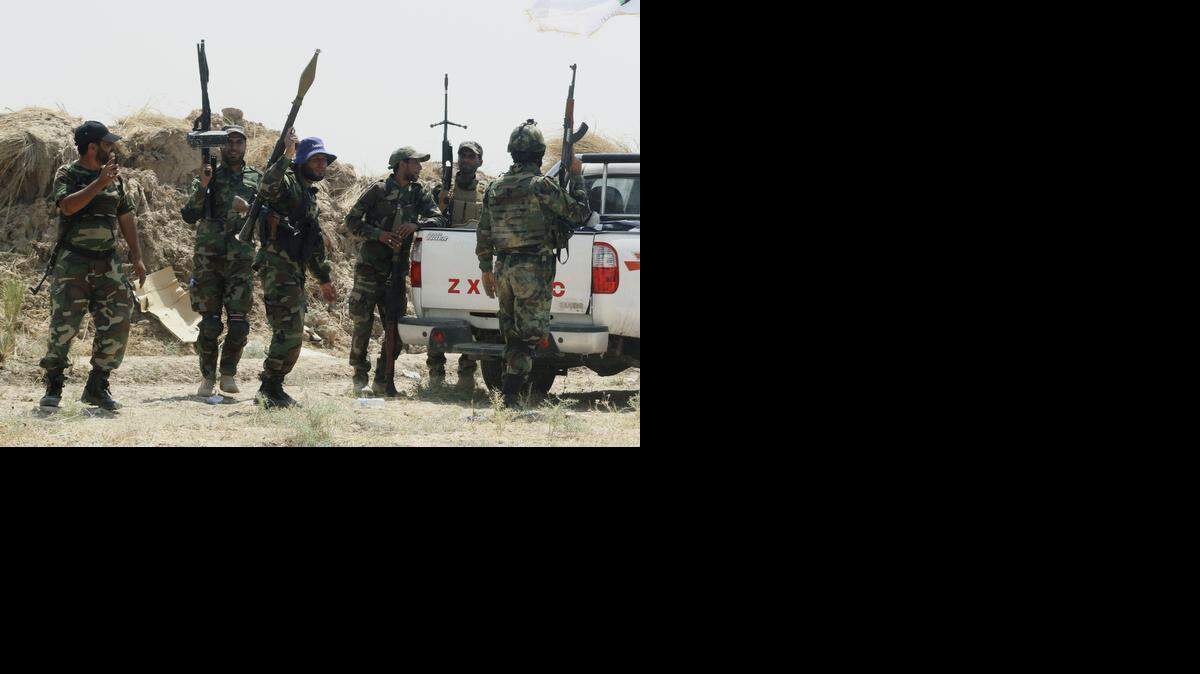 
Fuerzas de seguridad iraquíes y milicianos chiitas montan guardia tras un enfrentamiento con el Ejército Islámico en el norte de Irak, a fines de agosto.
