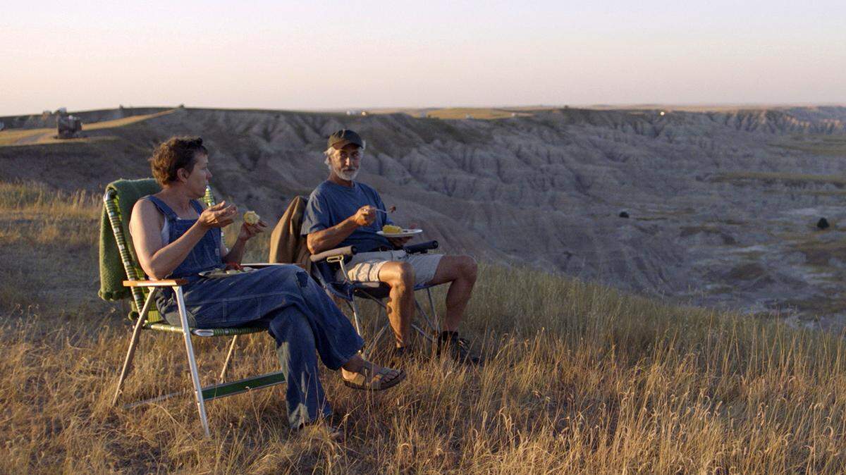 En esta imagen difundida por Searchlight Pictures, Frances McDormand (izq.) y David Strathairn en una escena de “Nomadland”. La película expone las dificultades de las personas mayores que se quedan sin trabajo y deben vivir en casas rodantes porque no tienen trabajos que paguen los suficiente para vivir en una vivienda fija.