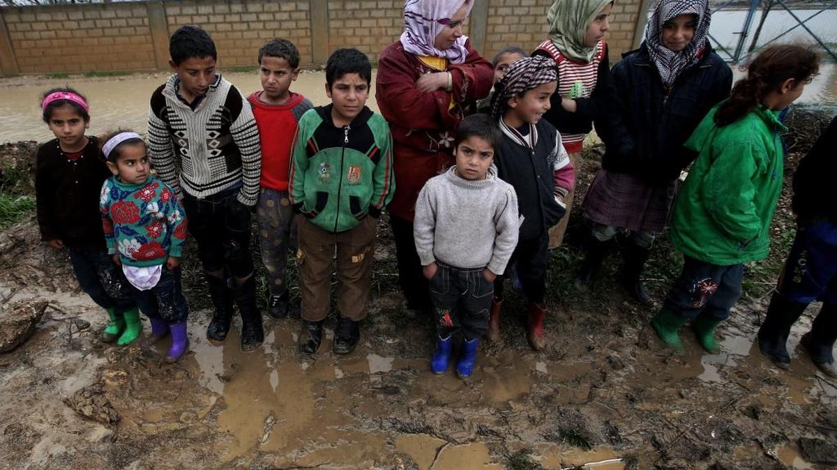 
Refugiados sirios comprueban cómo la lluvia ha inundado las tiendas en que viven en campos temporales en Al-Faour, en el Líbano 
