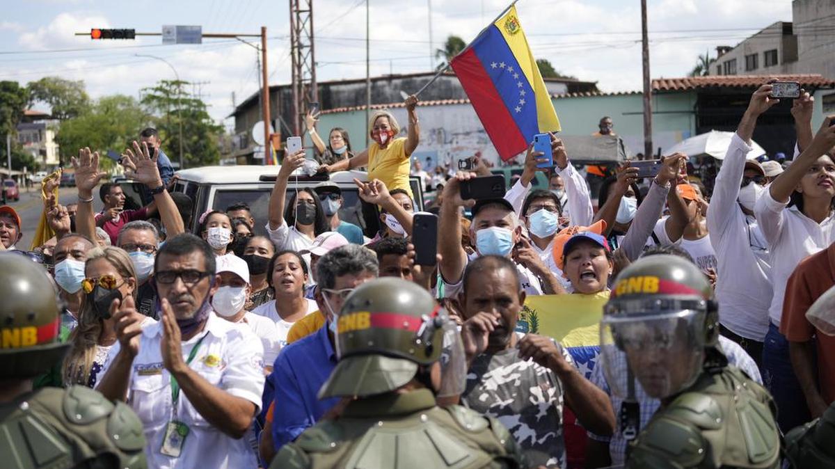 Los partidarios del gobernador electo del estado de Barinas, Sergio Garrido, se reúnen frente a la sede del consejo electoral regional, rodeados por la Guardia Nacional, donde Garrido recibe su certificado ganador en Barinas, Venezuela, el lunes 10 de enero de 2022, el día después de una repetición. elección. (Foto AP/Matías Delacroix)