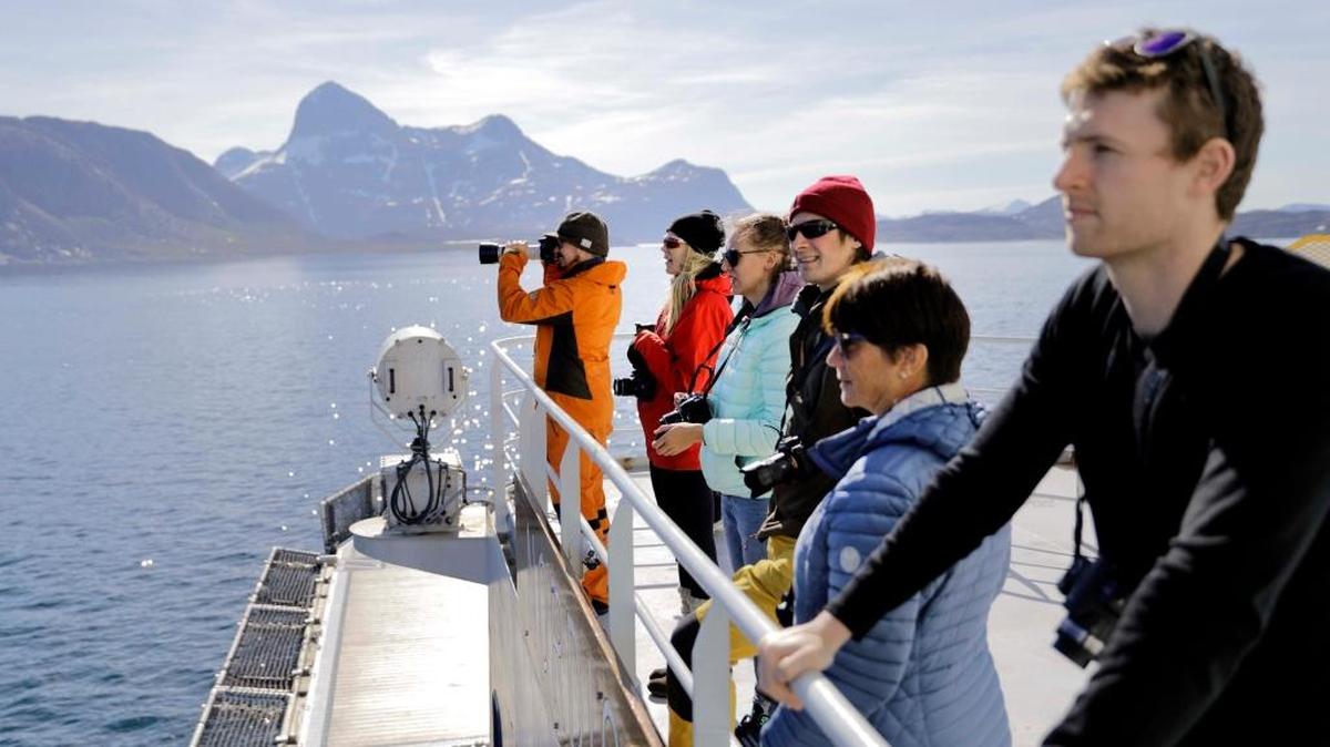 Personas a bordo del rompehielos finlandés MSV Nordica observan las costas de Groenlandia. El paso que une el océano Atlántico con el Pacífico a través del Ártico se abre más temprano y por más tiempo cada verano debido al cambio climático.