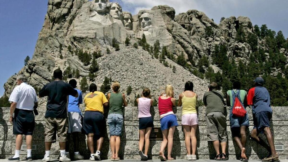 Visitantes observan los rostros de George Washington, Thomas Jefferson, Theodore Roosevelt y Abraham Lincoln en Mount Rushmore National Memorial en South Dakota.