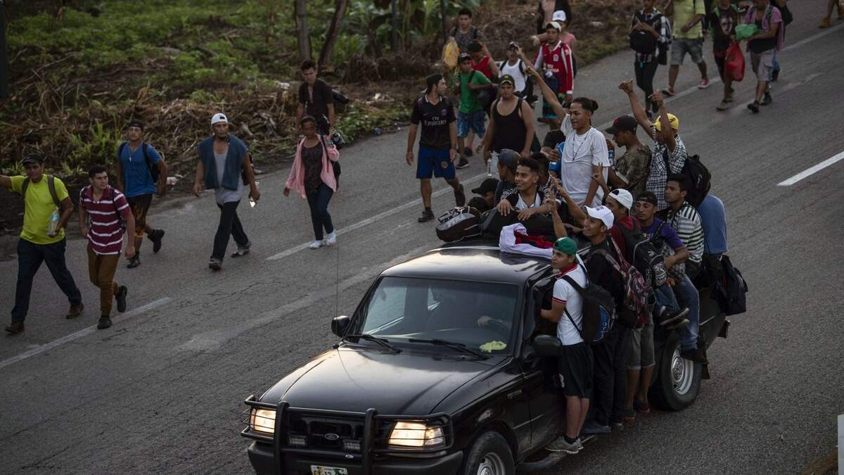 Inmigrantes hondureños caminando o en camionetas participan en una caravana en dirección a EEUU, desde Huixtla a Mapastepec, en el estado mexicano de Chiapas, el miércoles 24 de octubre de 2018.