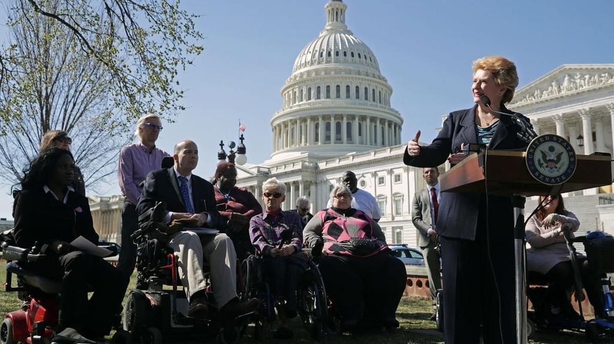 La senadora Debbie Stabenow (demócrata por Michigan) (der.) sostiene una conferencia de prensa en Washington con personas que podrían ser afectadas si se aprueba el propuesto plan de salud de los republicanos.