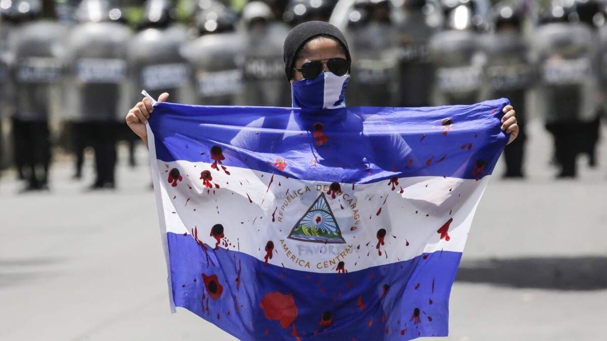 Un manifestante muestra una bandera pintada de rojo para aparentar manchas de sangre, durante una protesta contra el gobernante de Nicaragua, Daniel Ortega, el 16 de septiembre en Managua.