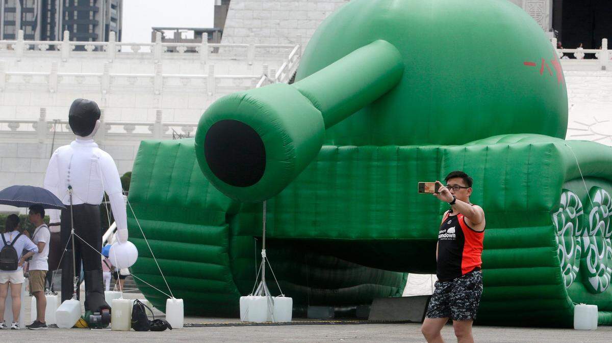 Un hombre en la Plaza Libertad en Taipéi, Taiwán, toma una selfie el sábado, 1 de junio de 2019, de una obra de arte de la icónica imagen de las protestas en la Plaza Tiananmen en Pekín, China. Un artista construyó figuras inflables del hombre que desafió a varios tanques chinos el 5 de junio de 1989.