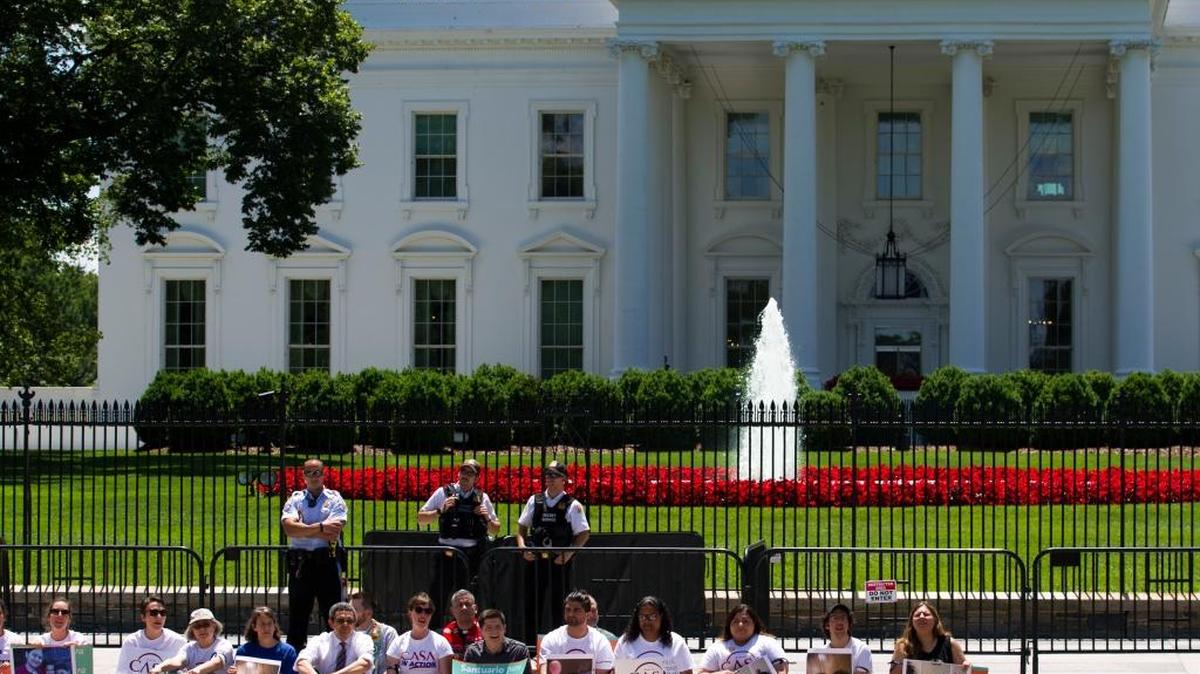 Manifestantes protestan sentados en la Casa Blanca el 1ro de junio para pedirle al presidente Trump que detenga las deportaciones de inmigrantes.
