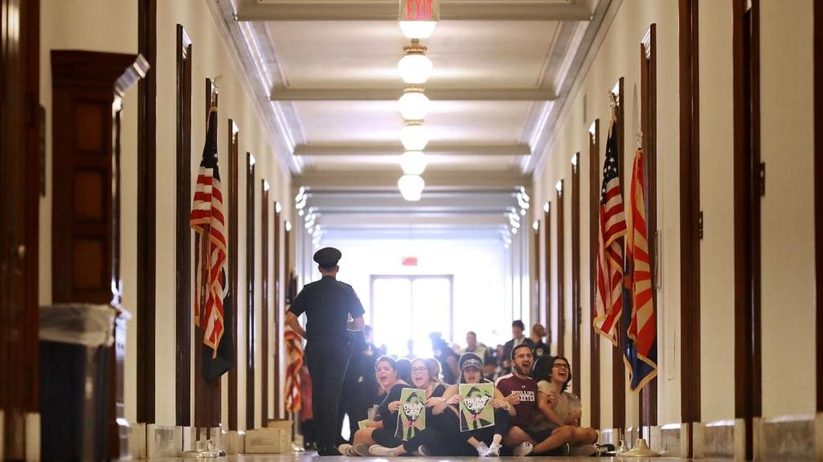 Un grupo de manifestantes de Arizona protestan frente a la oficina del senador Jeff Flake en el Capitolio, Washington, DC., el 10 de julio.