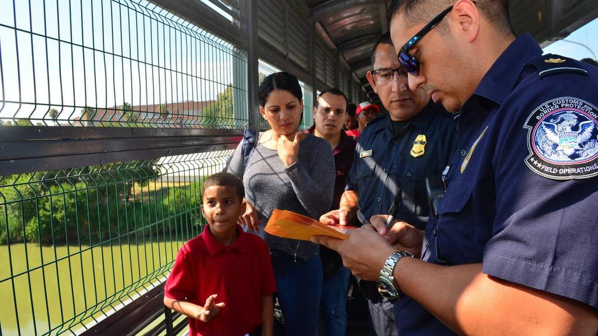 Agentes de la Oficina de Aduanas y Protección Fronteriza de los Estados Unidos procesan a unos migrantes cubanos, al cruzar el puente internacional entre Nuevo Laredo, México, y Laredo, Texas, el miércoles 10 de julio de 2019.