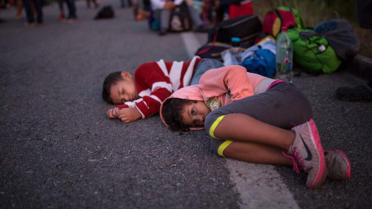 Unos niños esperan por un medio de transporte cerca de Tapanatepec, México. Los niños son parte de la caravana de inmigrantes que se dirigen a la frontera con EEUU.