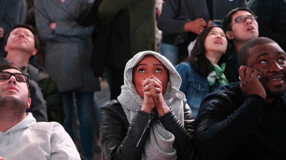 Un grupo de personas escucha los resultados de las elecciones en Times Square, Nueva York, Tuesday, el 8 de noviembre.