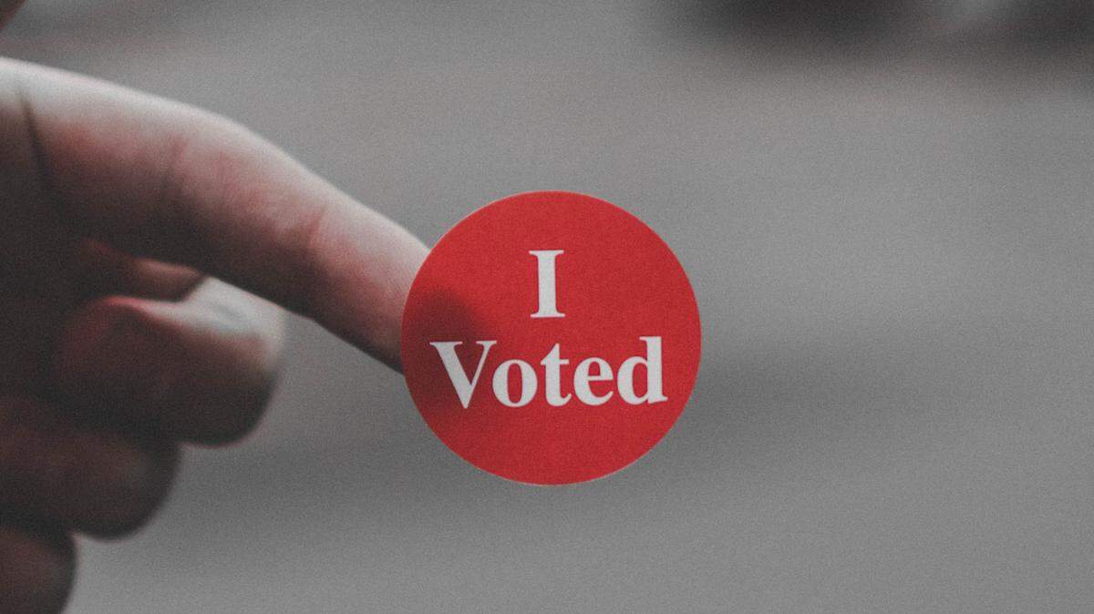 Un elector muestra la etiqueta que le dieron después de votar. 