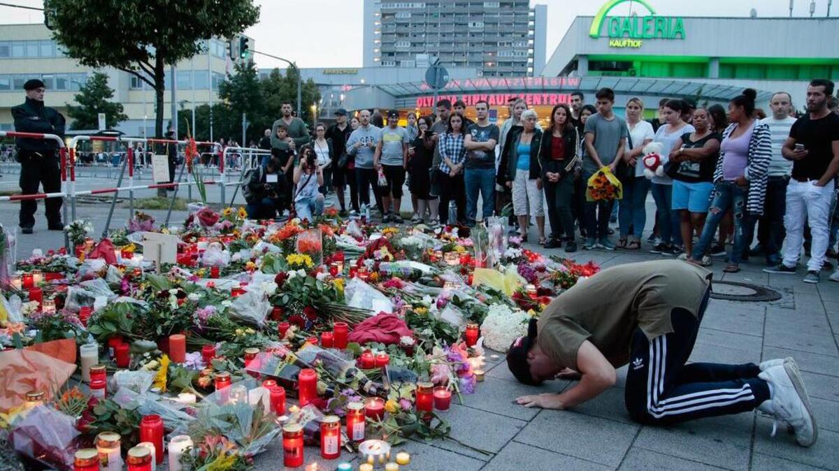 Varias personas rinden tributo a las víctimas del atentado cometido el 22 de julio en un centro comercial de Munich por un joven alemán de origen iraní.