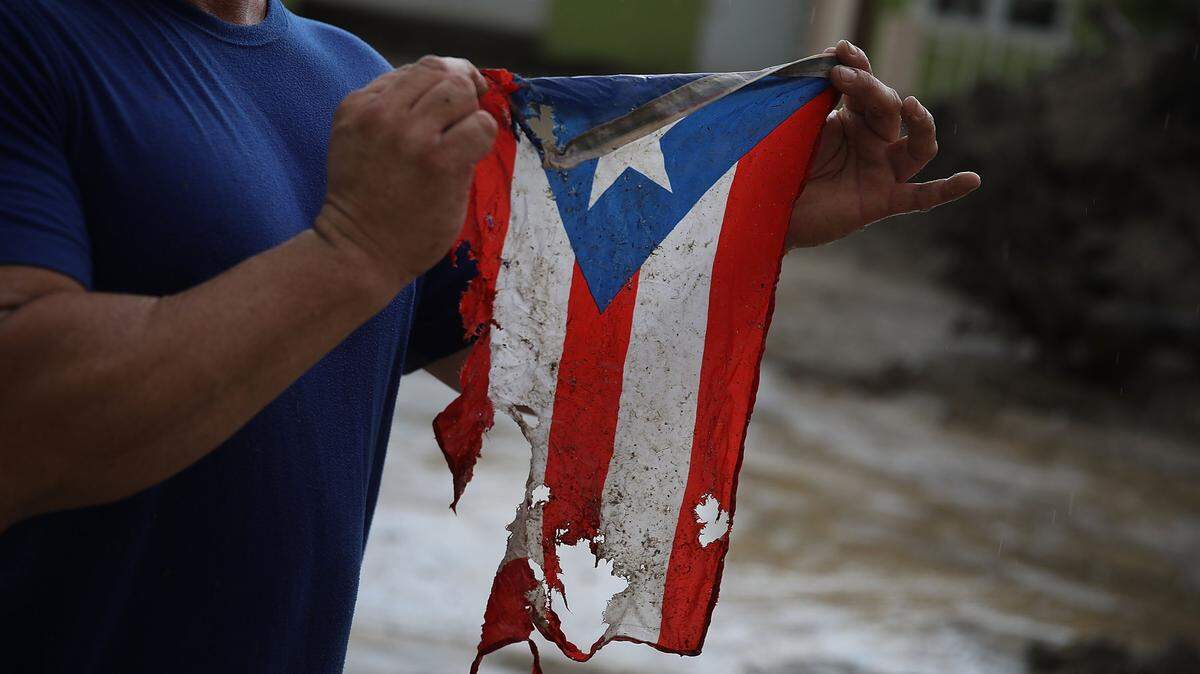 José Javier Santana muestra una bandera de Puerto Rico que se encontró en el piso en Utuado, el 6 de octubre de 2017, después que el huracán María azotó la isla.