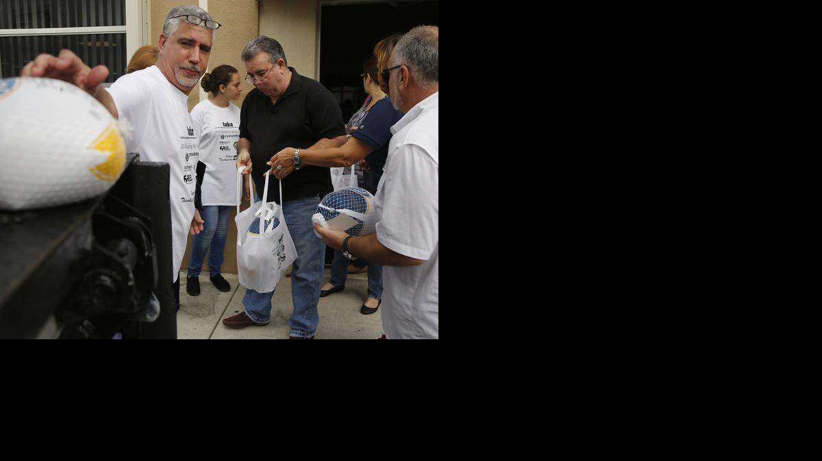 
Miembros de la Latin American Business Association entregan pavos y bolsas de regalos para la celebración de Acción de Gracias a residentes de Hialeah Gardens el pasado domingo.
