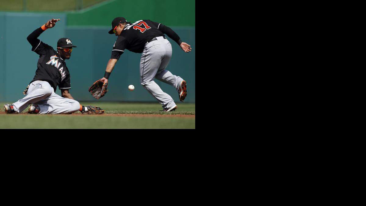 
El campo corto de los Miami Marlins, Adeiny Hechavarria (izq.), y el segunda base Donovan Solano no logran evitar un hit en un partido contra los Washington Nationals, este viernes.
