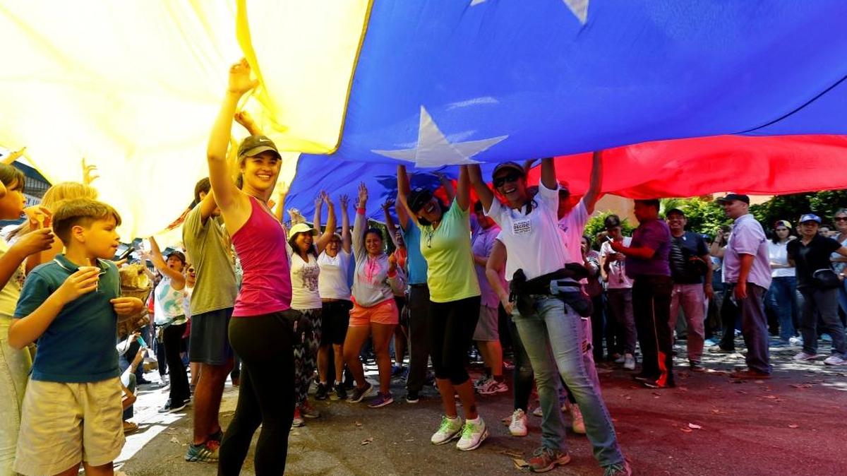 Miembros de la oposición ondean la bandera en un centro de votación para el referendo sobre la Constituyente, el 16 de julio, en Caracas.