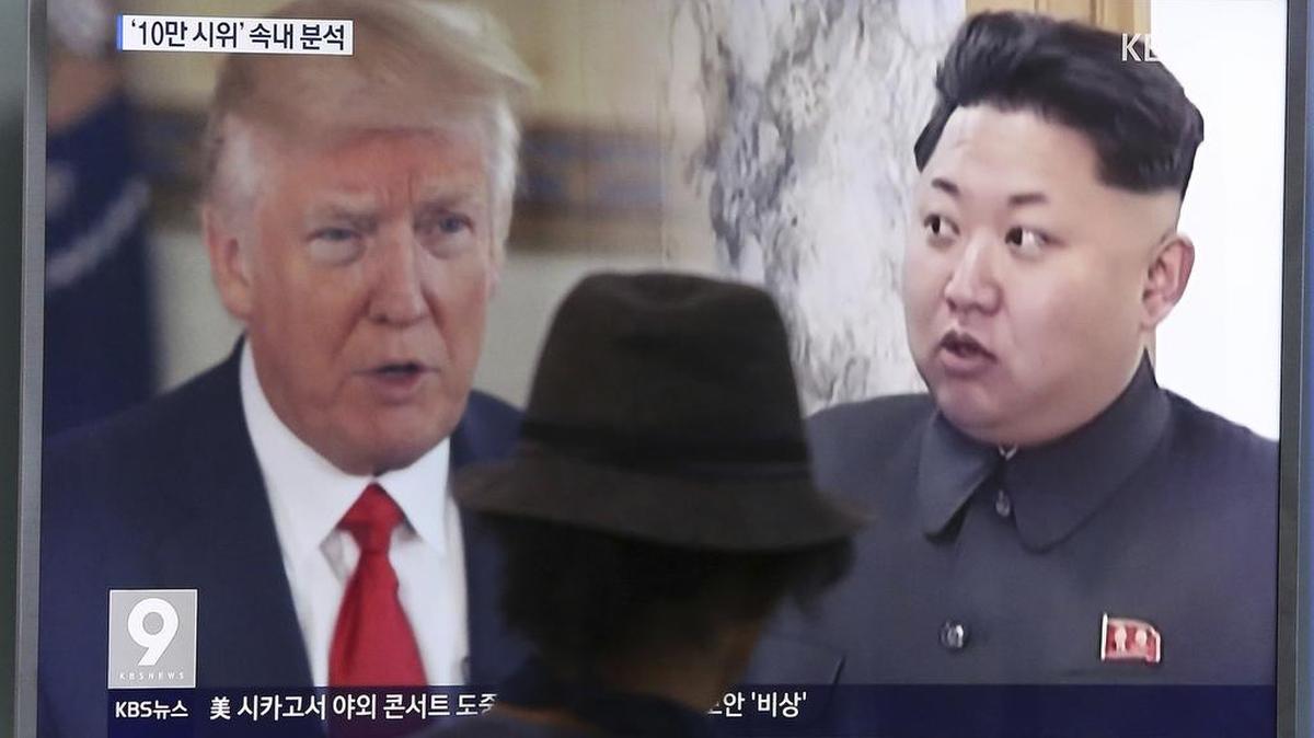 Un transeúnte en Seúl observa al presidente de EEUU, Donald Trump (izq.), y al líder norcoreano Kim Jong Un en un noticiero de televisión.