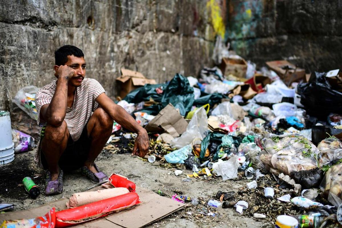 Un hombre espera para conseguir algo de comer en un basural en el vecindario Minas de Baruta, en Caracas, Venezuela, el 14 de m arzo del 2019.
