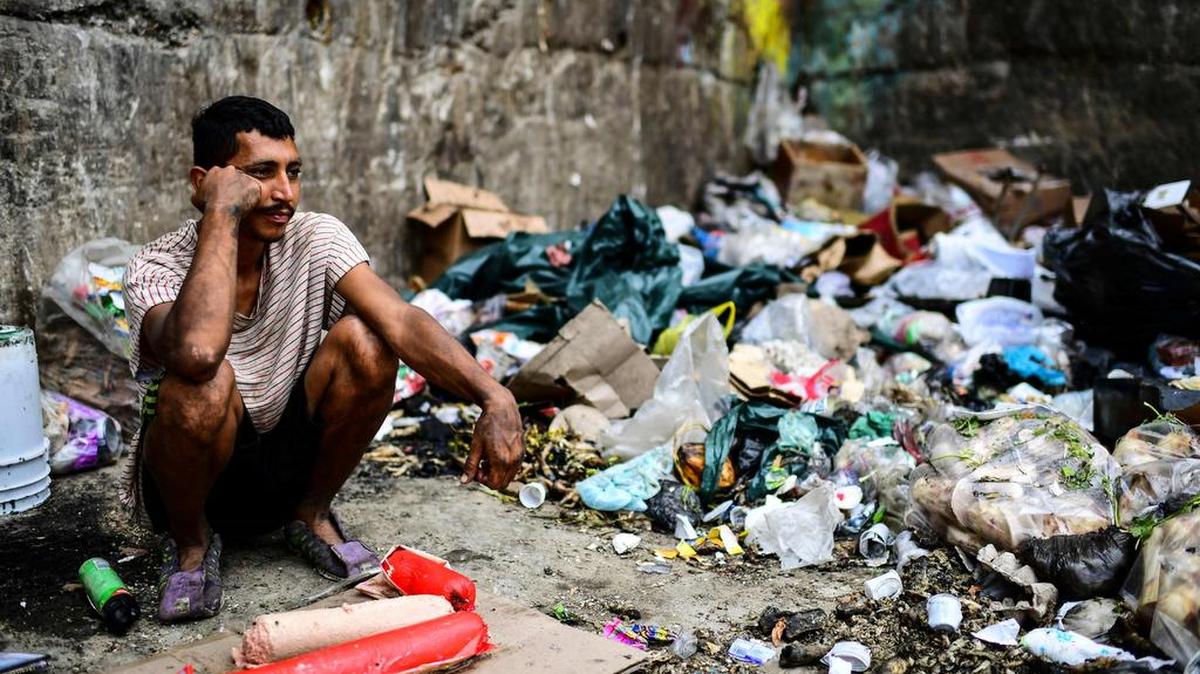 Un espera por un nuevo cargamento de basura para buscar comida, el jueves en Las Minas de Baruta, un barrio de Caracas.