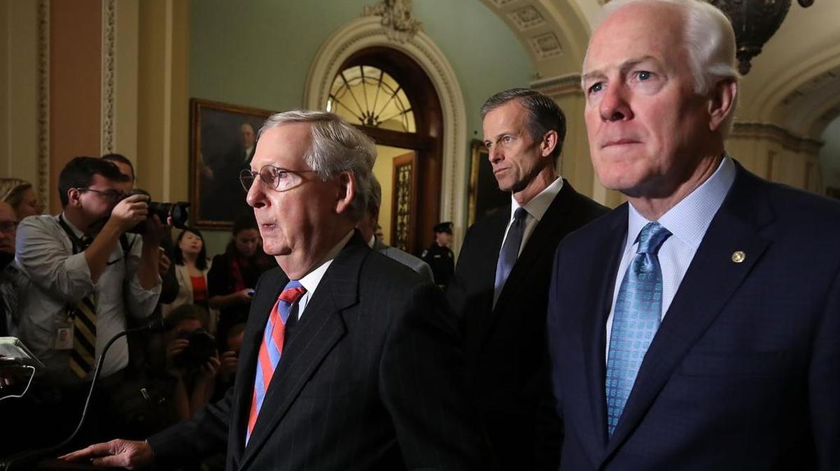 El líder de la mayoría del Senado, Mitch McConnell (centro), republicano por Kentucky, habla con la prensa en el Capitolio sobre la reforma de impuestos aprobada en el Senado.