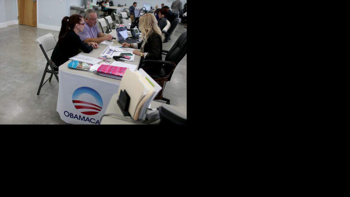 
Una asesora de seguros ayuda a dos personas a inscribirse en el Obamacare el pasado 5 de febrero en Miami.

