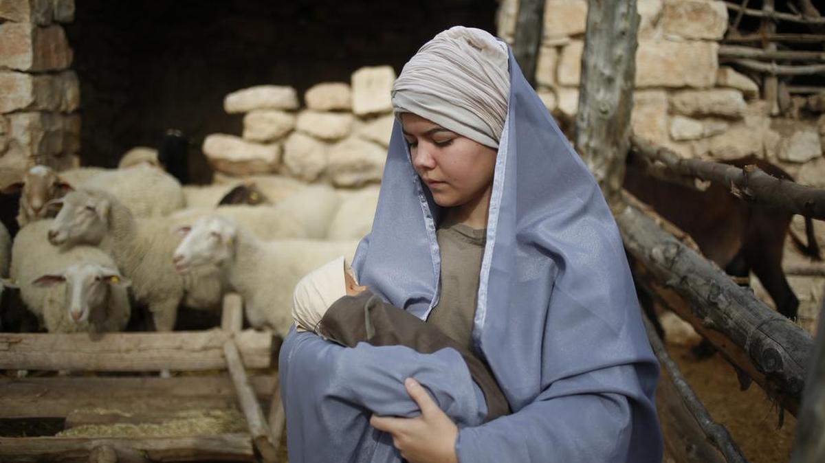 Una actriz cristiana interpreta a la Virgen María sosteniendo al Niño Jesús en una recreación de la Natividad durante las fiestas navideñas en la ciudad israelí de Nazaret, el 21 de diciembre.