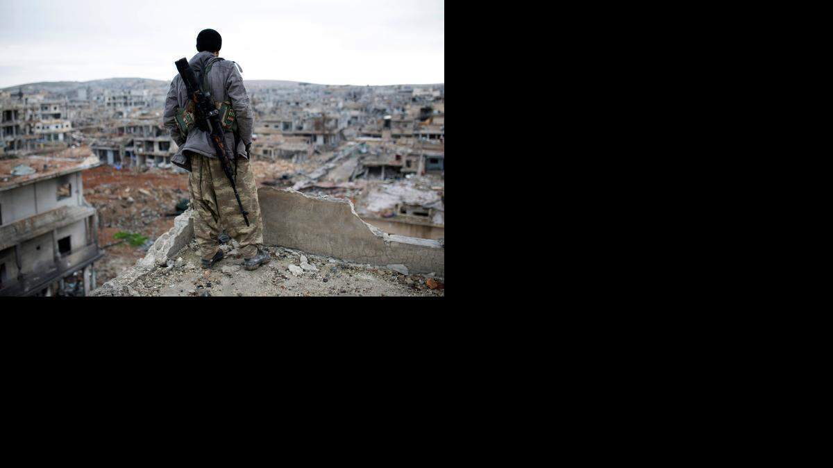 
Un francotirador kurdo mira los escombros de la ciudad siria de Kobani, luego de haberse anotado una victoria en contra de los atacantes del Estado Islámico.


