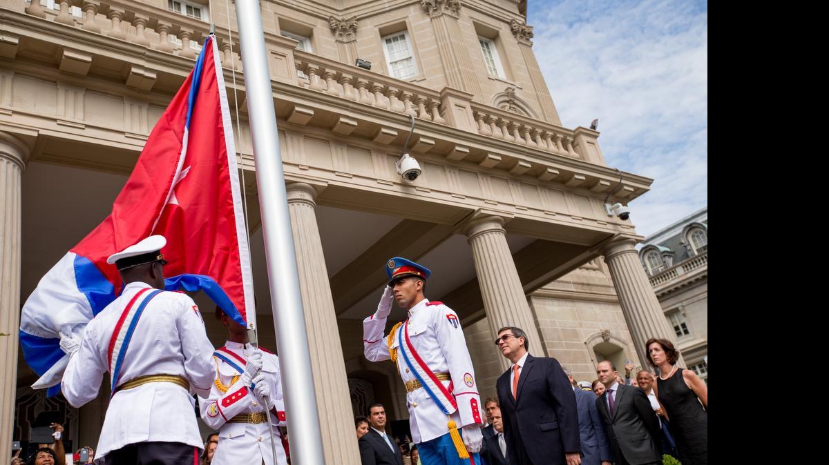 
Guardias cubanos preparan la bandera para que la ice el canciller Bruno Rodríguez (der.), al abrir la nueva embajada de Cuba en Washington.
