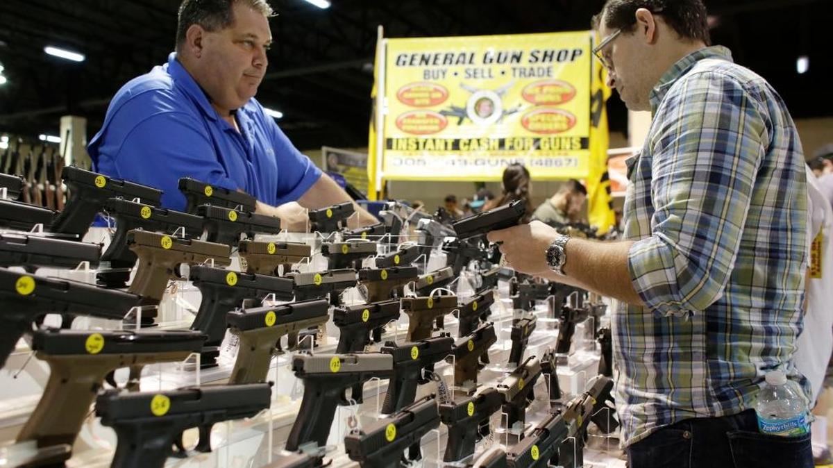 Un comprador examina una pistola Glock en una feria de armas realizada el sábado pasado en Miami.
