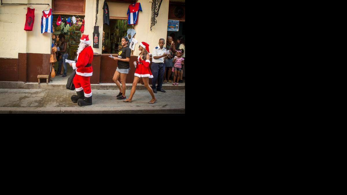 
Personas con disfraces de Santa Claus promueven un restaurante particular en La Habana, el martes pasado, después del anuncio del restablecimiento de las relaciones entre EEUU y Cuba.
