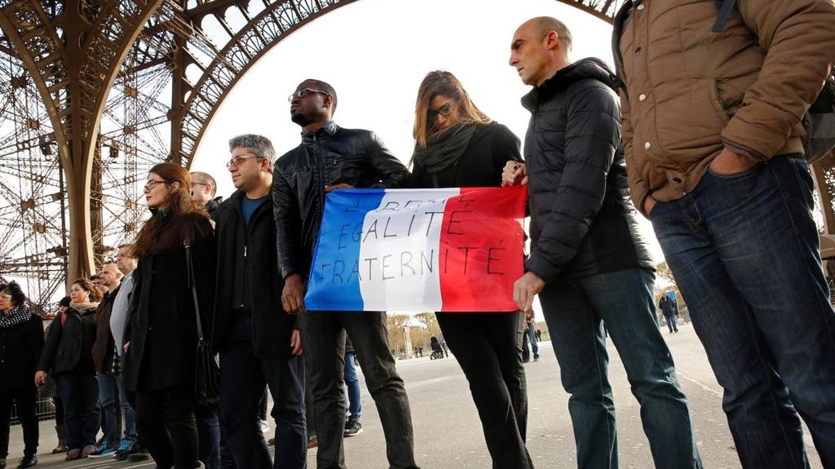 Residentes de París observan un momento de silencio bajo la torre Eiffel este lunes, en recuerdo de las víctimas del ataque terrorista.