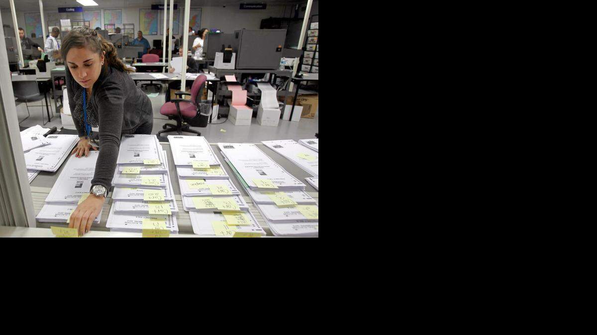 
Una trabajadora del Departamento de Elecciones de Miami-Dade ordena un grupo de boletas ausentes en Doral, el miércoles pasado.
