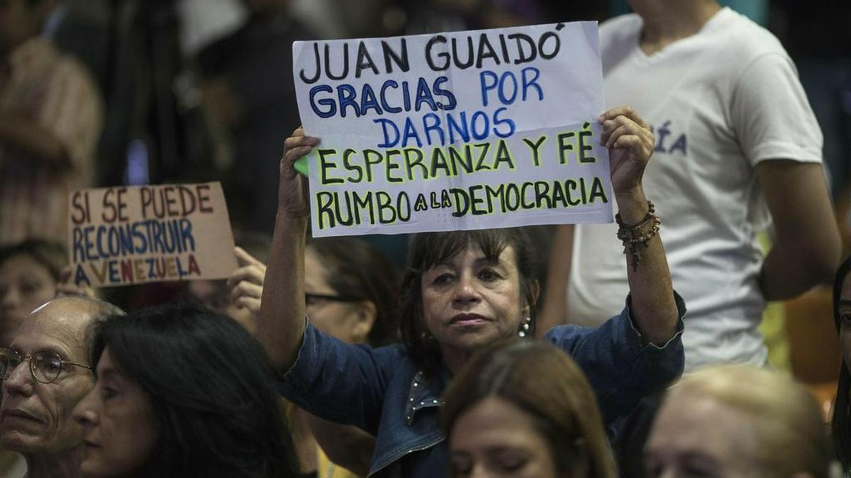 Simpatizantes de Juan Guaidó, presidente de la Asamblea Nacional y presidente interino de Venezuela, muestran su apoyo el jueves en Caracas, cuando se anunción un plan para ayudar a reconstruir el país.