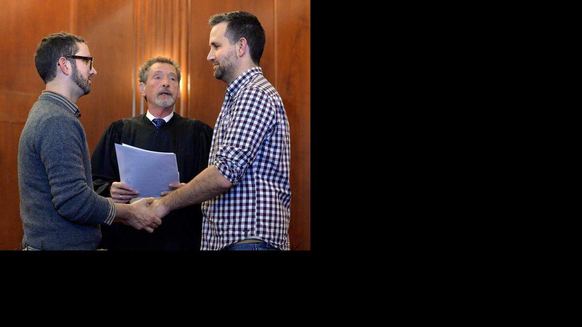 
Vernon Scoville oficia el matrimonio de Robert Gann (izq.) y John Kenny Rodricks en la corte del condado Jackson en Kansas City, Missouri.
