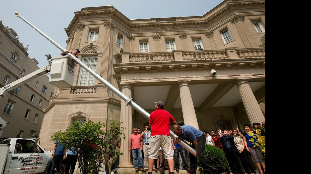
Varios trabajadores colocan este miércoles un asta de bandera en la Sección de Intereses de Cuba en Washington, en previsión de la reapertura de embajadas.

