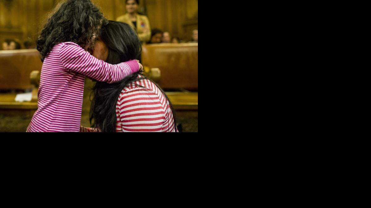 
Una inmigrante abraza a su hija durante una reunión de la Junta de Supervisores de San Francisco en esa ciudad de California el 16 de septiembre. 
