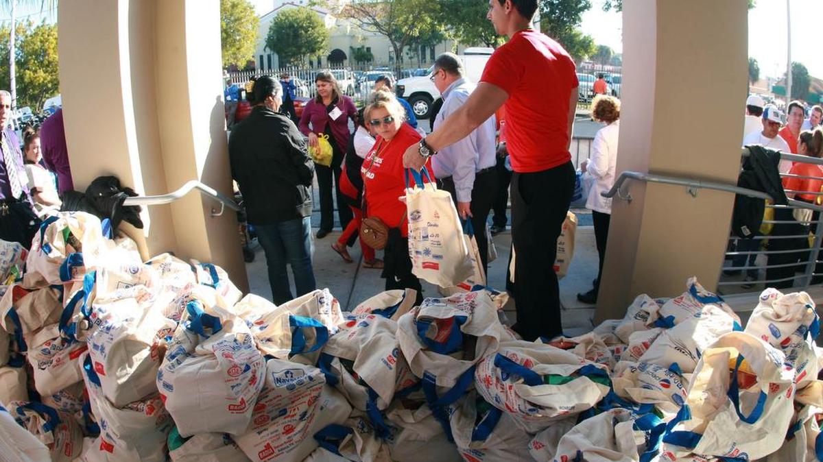 Personas de bajos ingresos reciben alimentos en las oficinas de la Cámara de Comercio Latina (Camacol), en Miami, en el 2014.