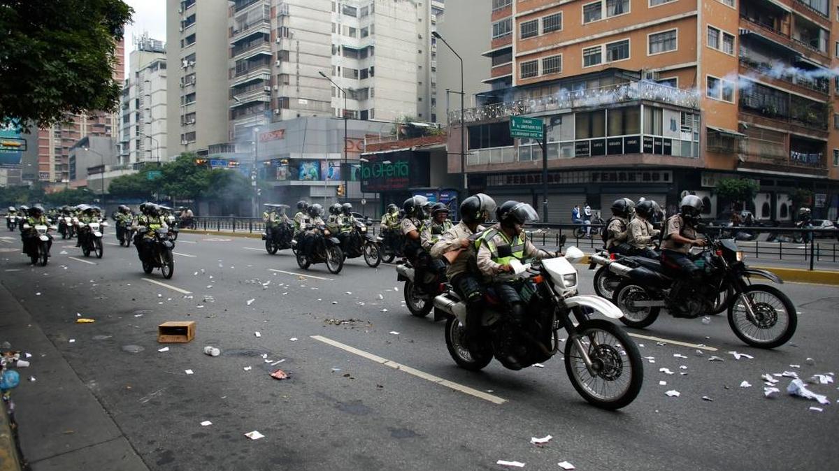 Agentes de policía recorren una avenida en Caracas, durante protestas contra el gobierno el pasado 20 de abril.