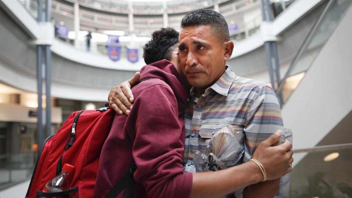 Edvin Cazun, de Guatemala (der.), abraza a su hijo Samuel al reunirse en el Aeropuerto Internacional de Cincinnati el 23 de julio, después que haber estado separados durante un mes tras cruzar la frontera.