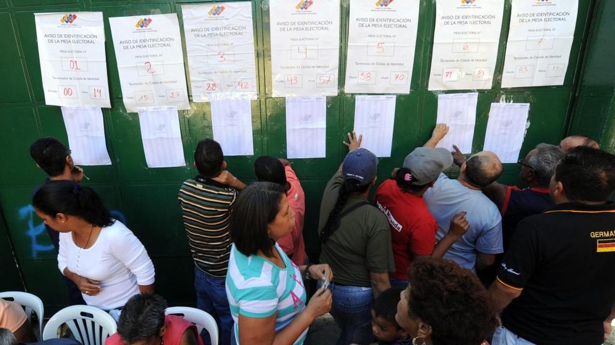 Votantes buscan sus nombres en una lista electoral durante comicios realizados en Caracas en diciembre del 2013.