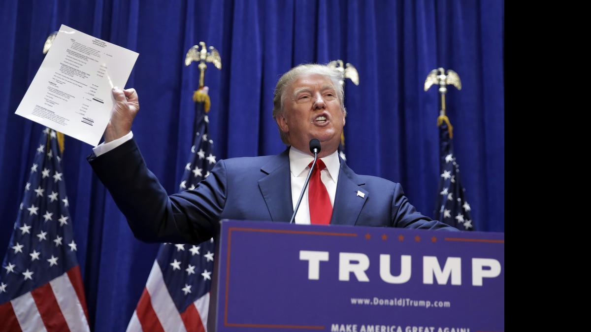 
El urbanizador Donald Trump muestra una copia de su patrimonio neto al anunciar su aspiración a la presidencia el martes pasado en Nueva York.
