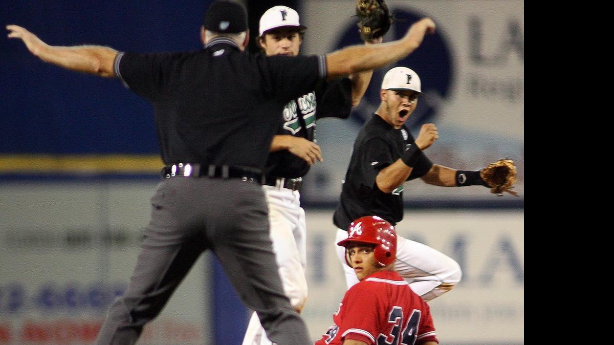 
Esta imagen de archivo muestra la típica pose que anuncia a todos que la jugada es buena. Atrás (der.) reacciona el shortstop de Flanagan, Ricky Santiago, mientras que Oscar Capote, del American-Hialeah, se roba la base en este juego de FHSAA clase 6A de mayo 2010. En la actualidad, si hay conflicto en la decisión, ésta se toma a distancia por un panel que revisa diferentes tomas.


