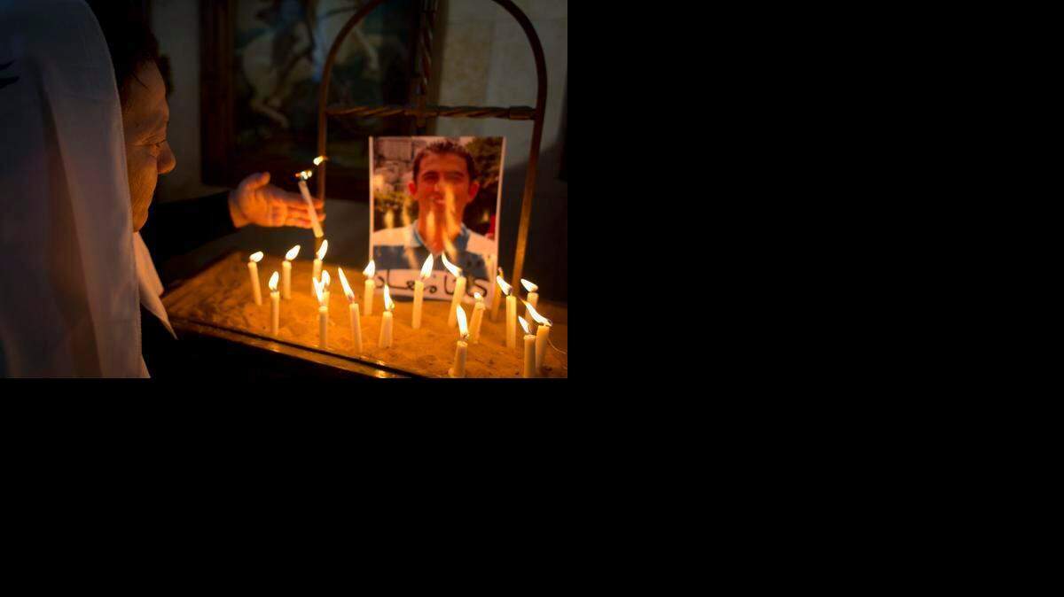 
Una mujer jordana enciende una vela por el bienestar del piloto jordano, Tte. Muath al-Kaseasbeh, antes de saberse de su muerte a manos de los yihadistas.


