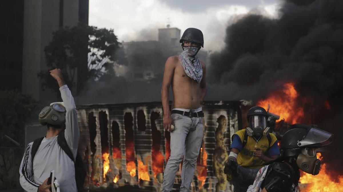 Las llamas consumen un camión incendiado por manifestantes en Caracas el 27 de mayo, durante choques con la policía.