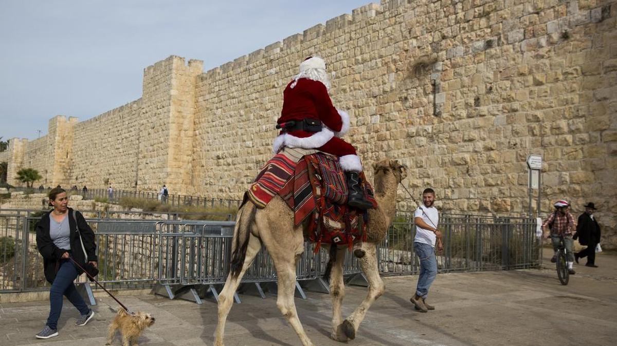 Un hombre disfrazado de Santa Claus pasea sobre un camello en la Ciudad Vieja de Jerusalén, el pasado 21 de diciembre.