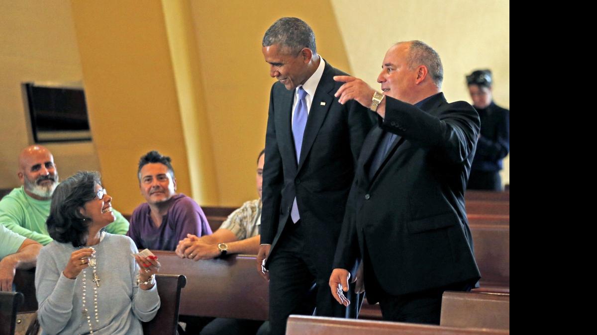 
El presidente Barack Obama (centro) visita la Ermita de la Caridad, acompañado por el sacerdote Juan Rumin Domínguez, el 28 de mayo.
