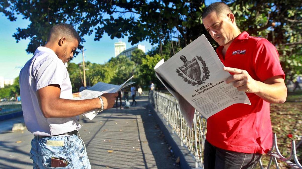 Dos hombres leen versiones impresas de la propuesta de la nueva Constitución en un estanquillo en La Habana. Los cubanos votarán en referendo el 24 de febrero la nueva Constitución.