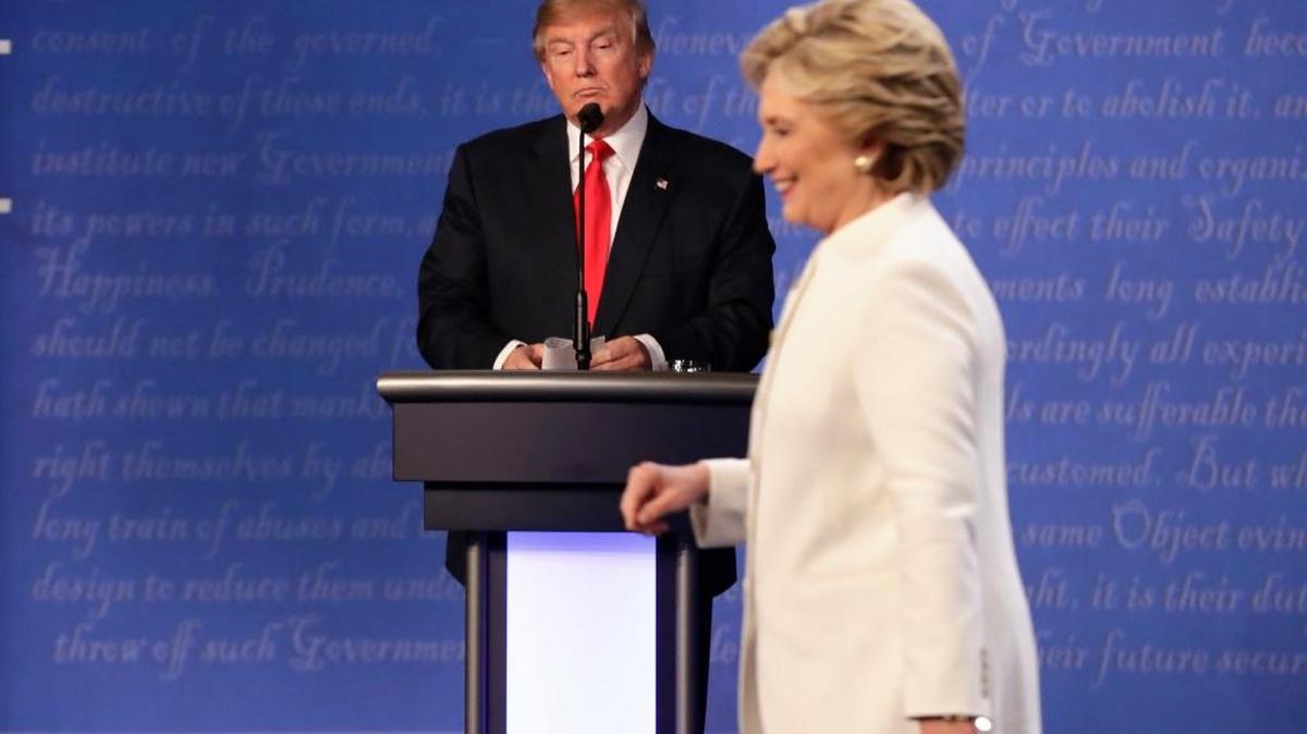 La candidata demócrata, Hillary Clinton, sale del escenario del tercer debate, en Las Vegas, mientras el candidato republicano, Donald Trump, espera en su podio.