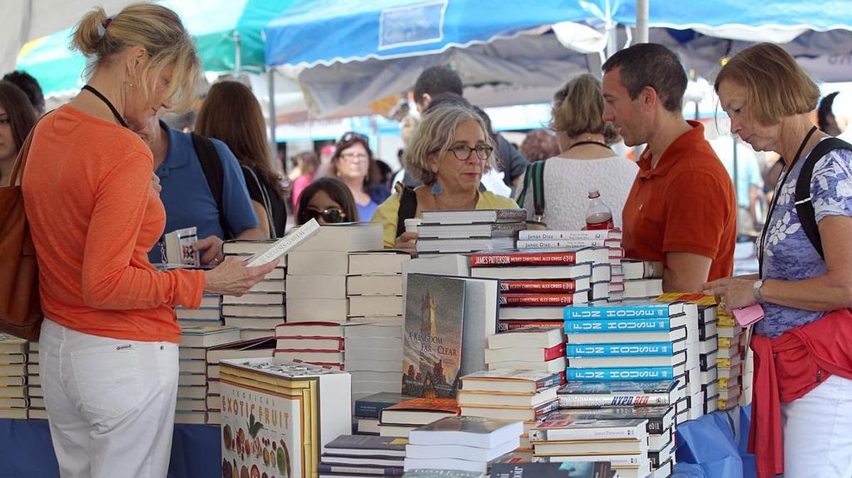 Amantes de la literatura hojean libros en la sección de la librería Books and Books en la Feria del Libro de Miami, en el 2012.